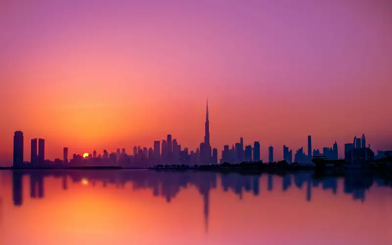 The Dubai skyline mirrored at sunset