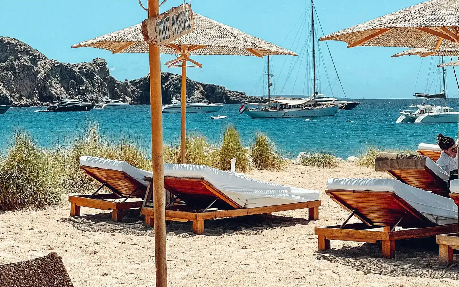 Sun loungers and sailboats on a quiet beach
