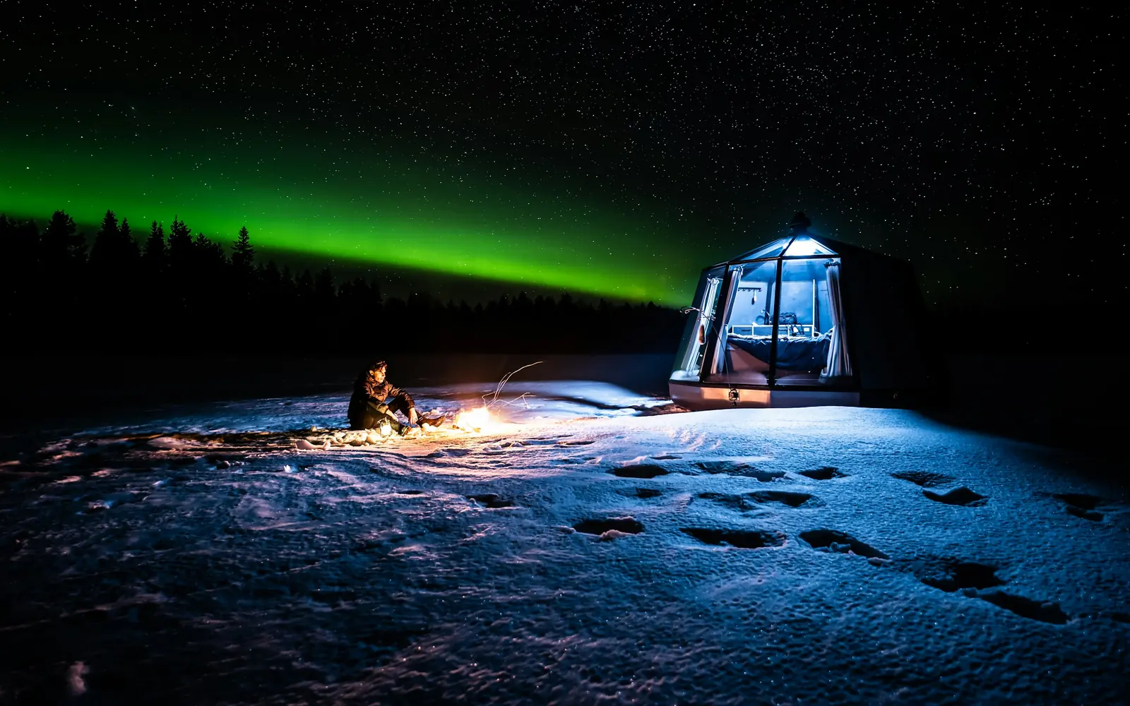 A glass igloo beneath the northern lights