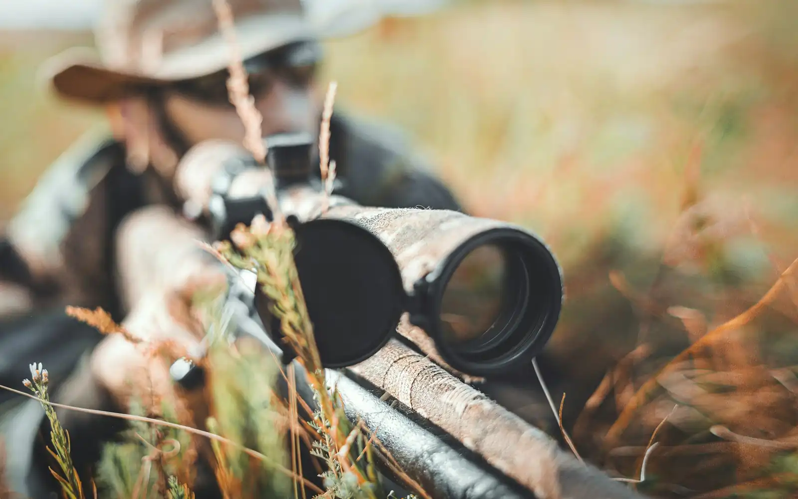 A rifle scope in the golden light of the bush