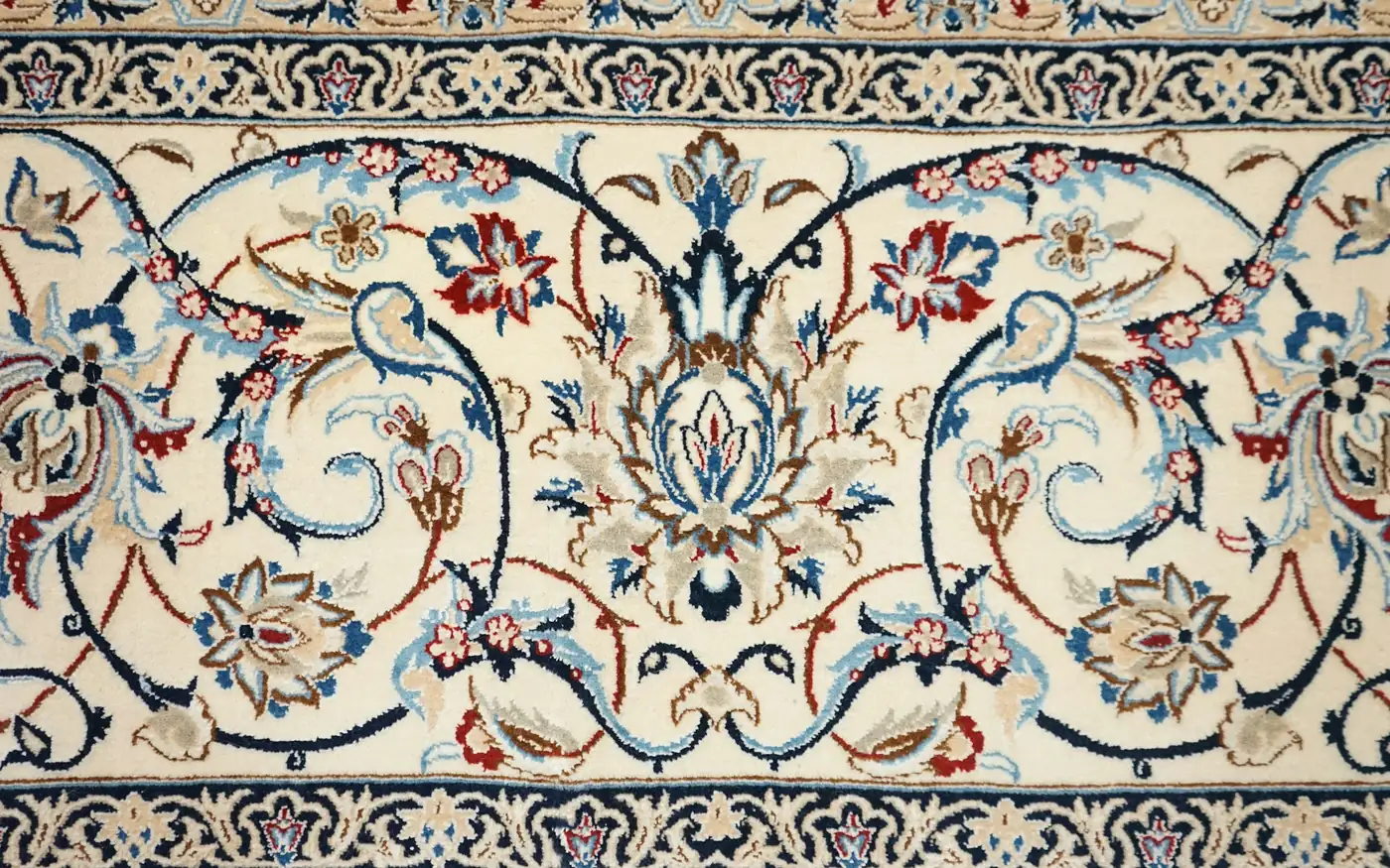 An ivory silk carpet with a flowing floral design