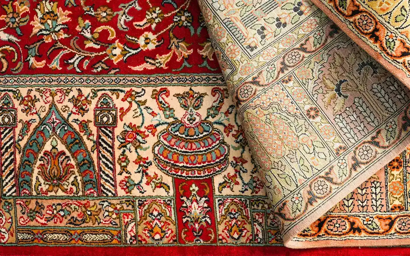 A handcrafted Persian silk carpet with its corner turned back to show the weave