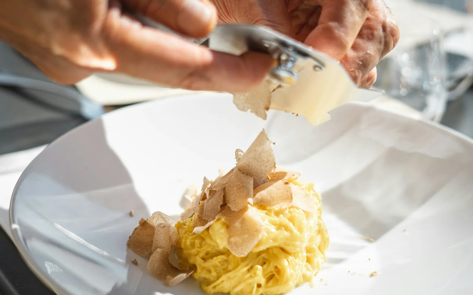 White Alba truffle being shaved over fresh tagliolini